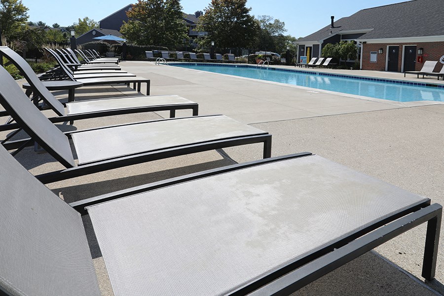 a row of lounge chairs next to a swimming pool