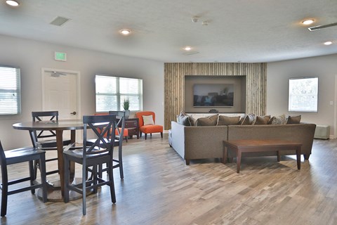 a living room with a table and chairs and a couch and a television