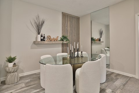 a dining room with white chairs and a glass table