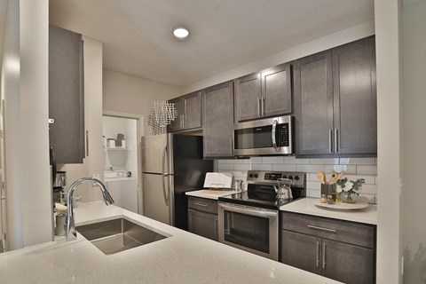 an open kitchen with stainless steel appliances and a sink