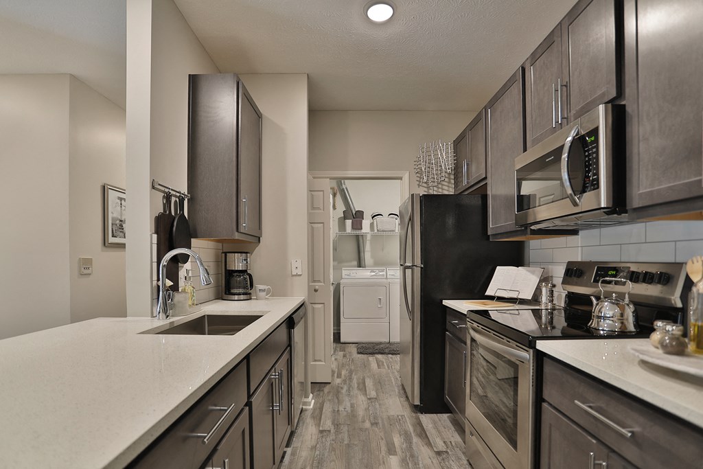 a kitchen with stainless steel appliances and white counter tops