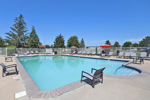 A large outdoor swimming pool surrounded by lounge chairs.