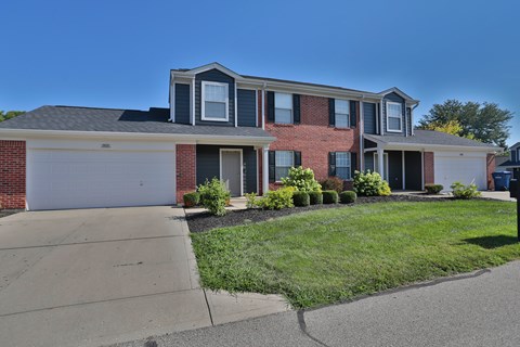 A red brick house with a white garage door.