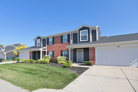 A house with a red brick facade and a grey roof.