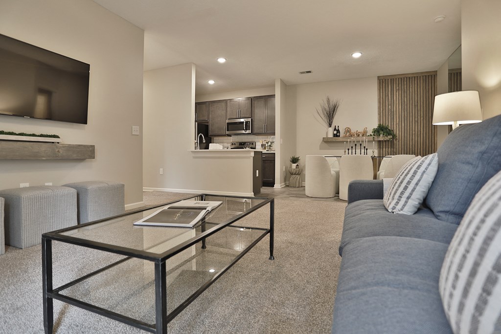 a living room with a blue couch and a glass coffee table
