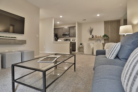 a living room with a blue couch and a glass coffee table