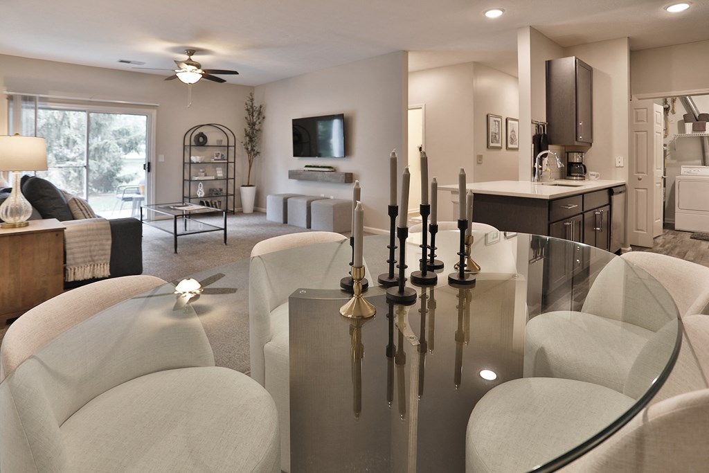 a living room with white chairs and a glass table
