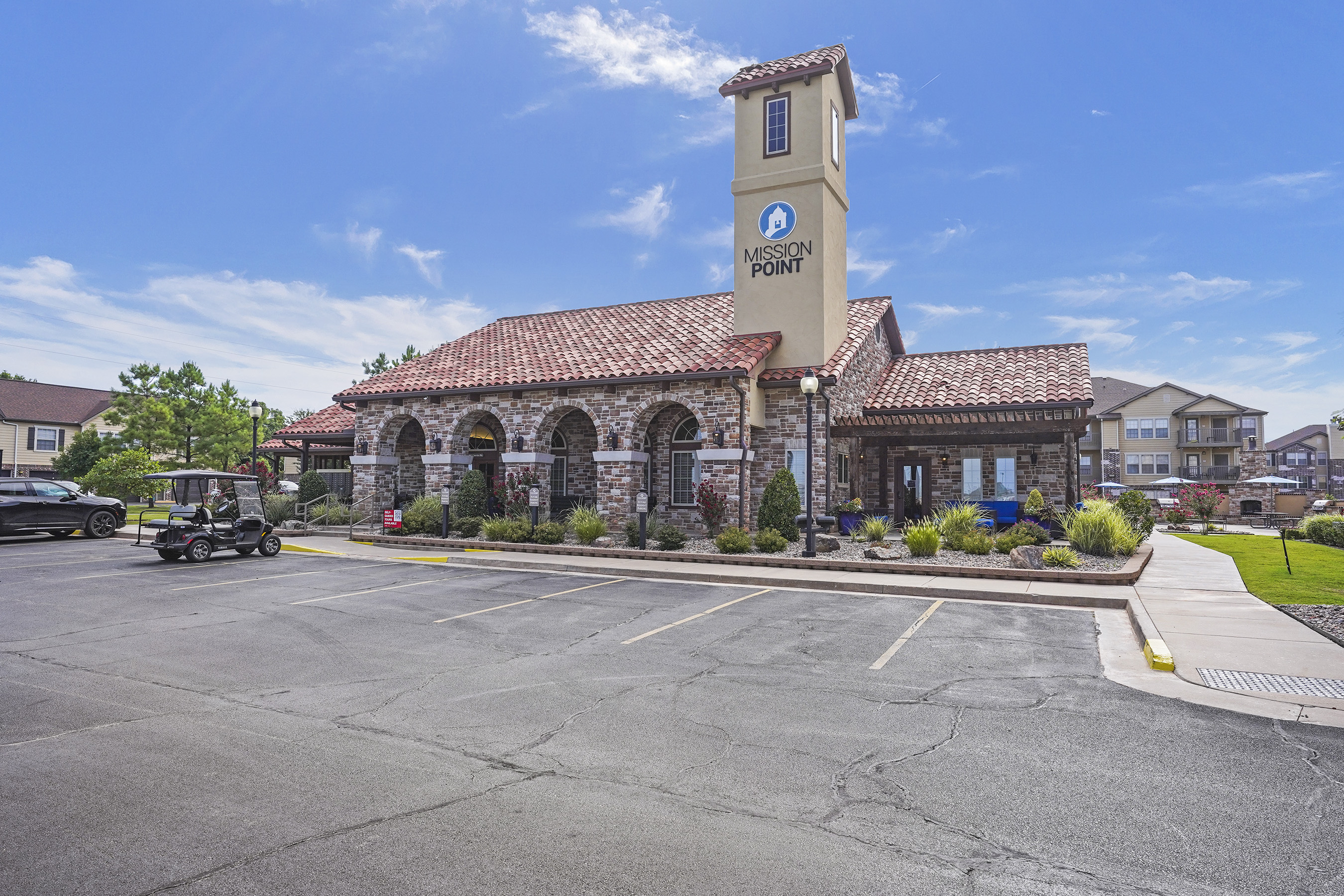A parking lot in front of a building with a clock tower.