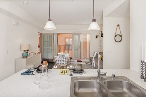 a kitchen with a sink and a view of a living room