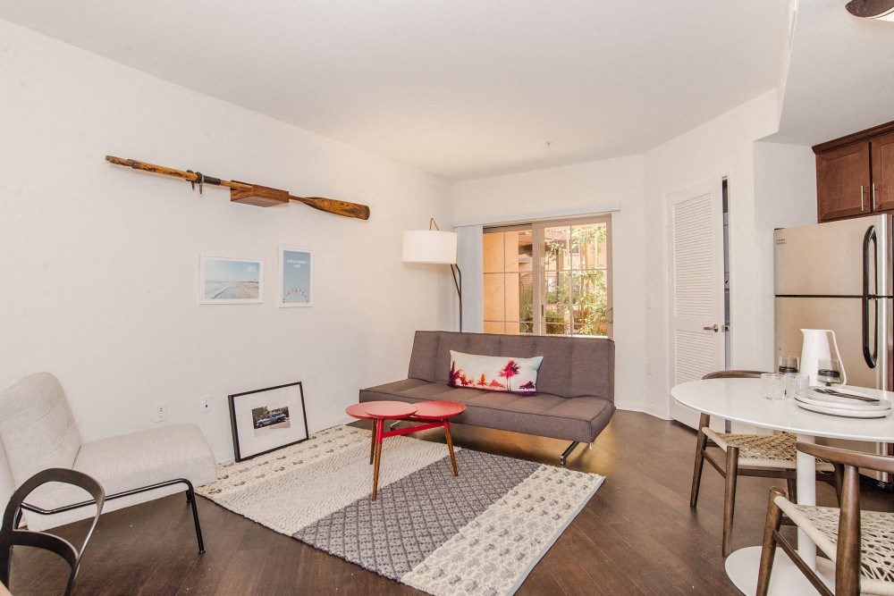 a living room with a couch and a table and a refrigerator