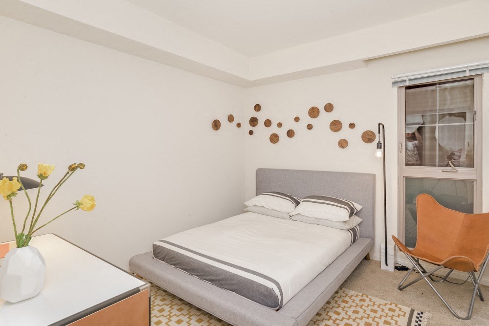 a bedroom with a bed and a desk and a window