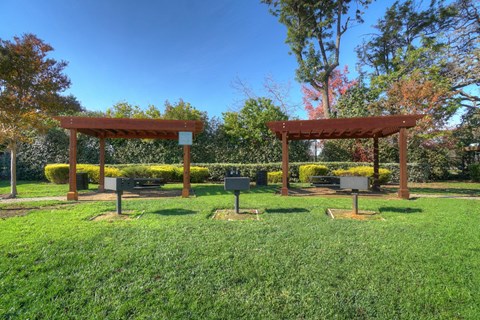 a park with two wooden structures in the grass
