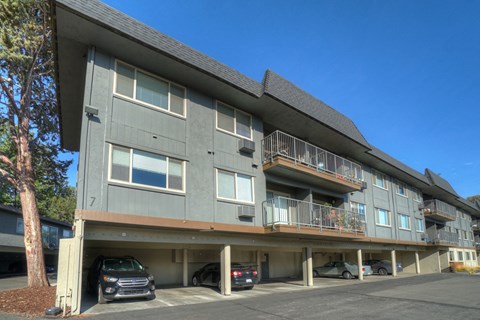 a large apartment building with cars parked in front of it
