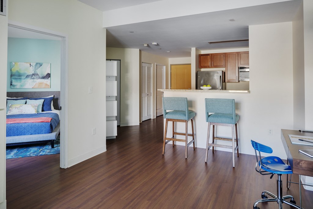 a view of a living room and kitchen with a dining area and a kitchen bar