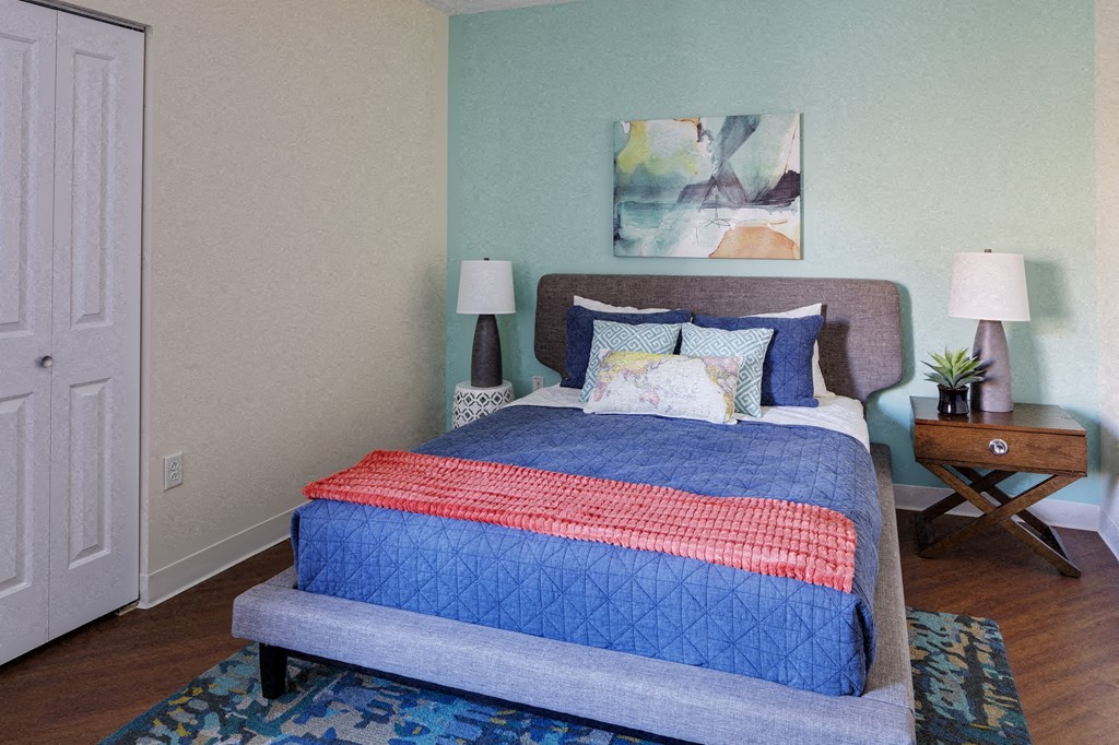 a bedroom with a bed with a blue comforter