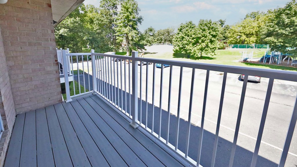 a white railing on a balcony overlooking a parking lot