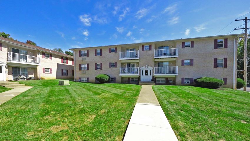 an apartment building with a lawn and a sidewalk