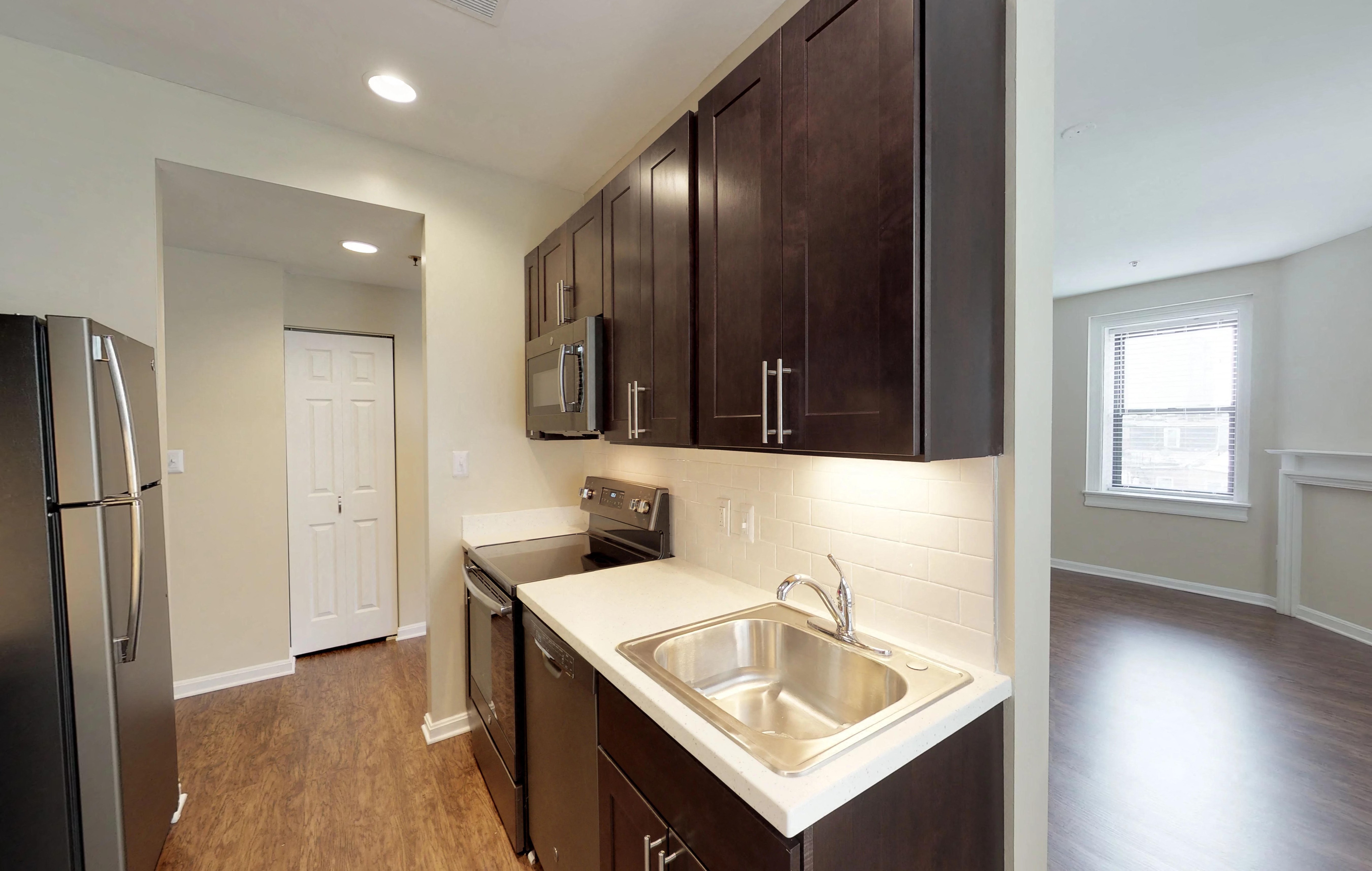 a kitchen with wooden cabinets and a stainless steel sink