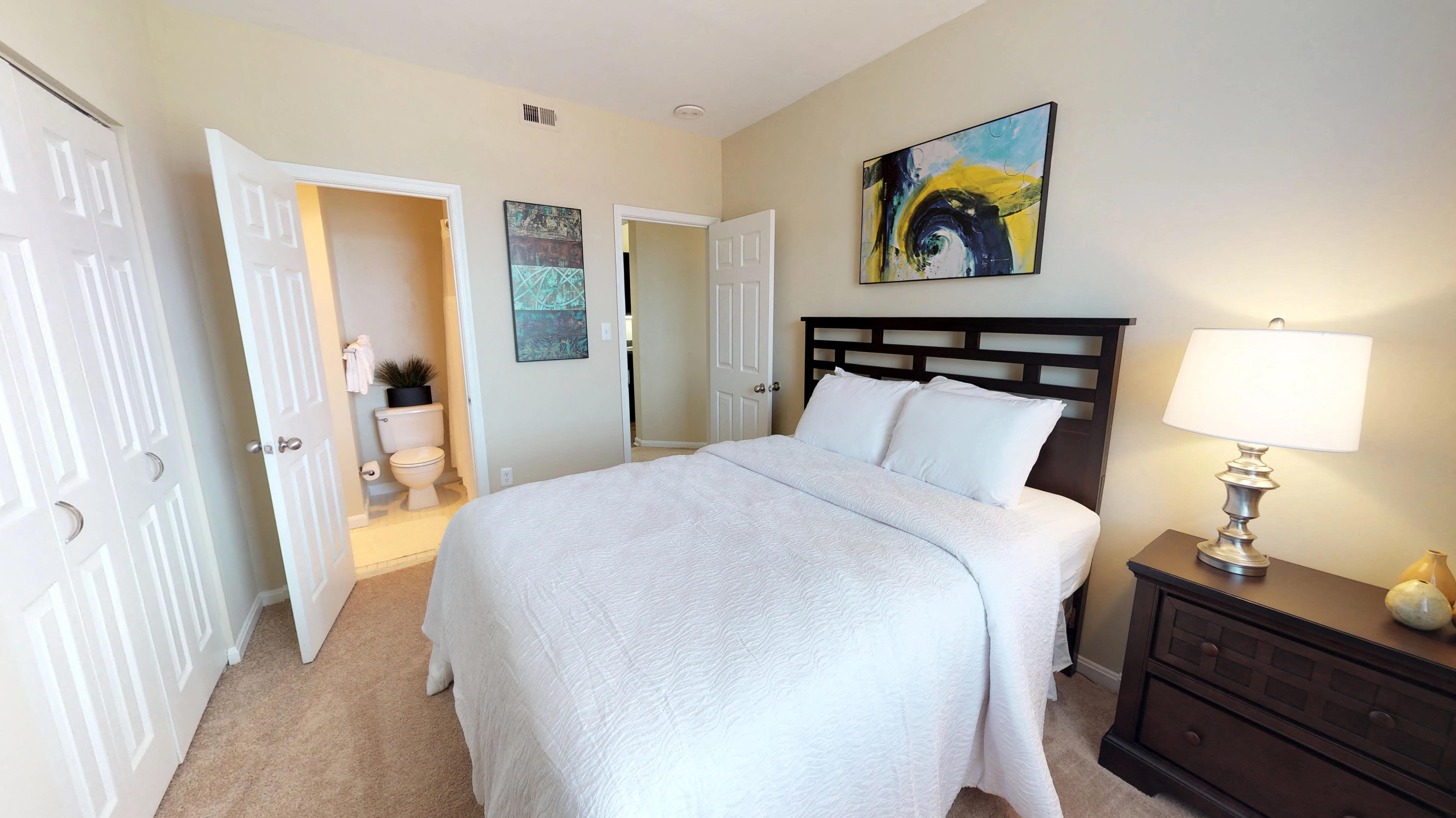 a bedroom with a bed and a bathroom with a toilet