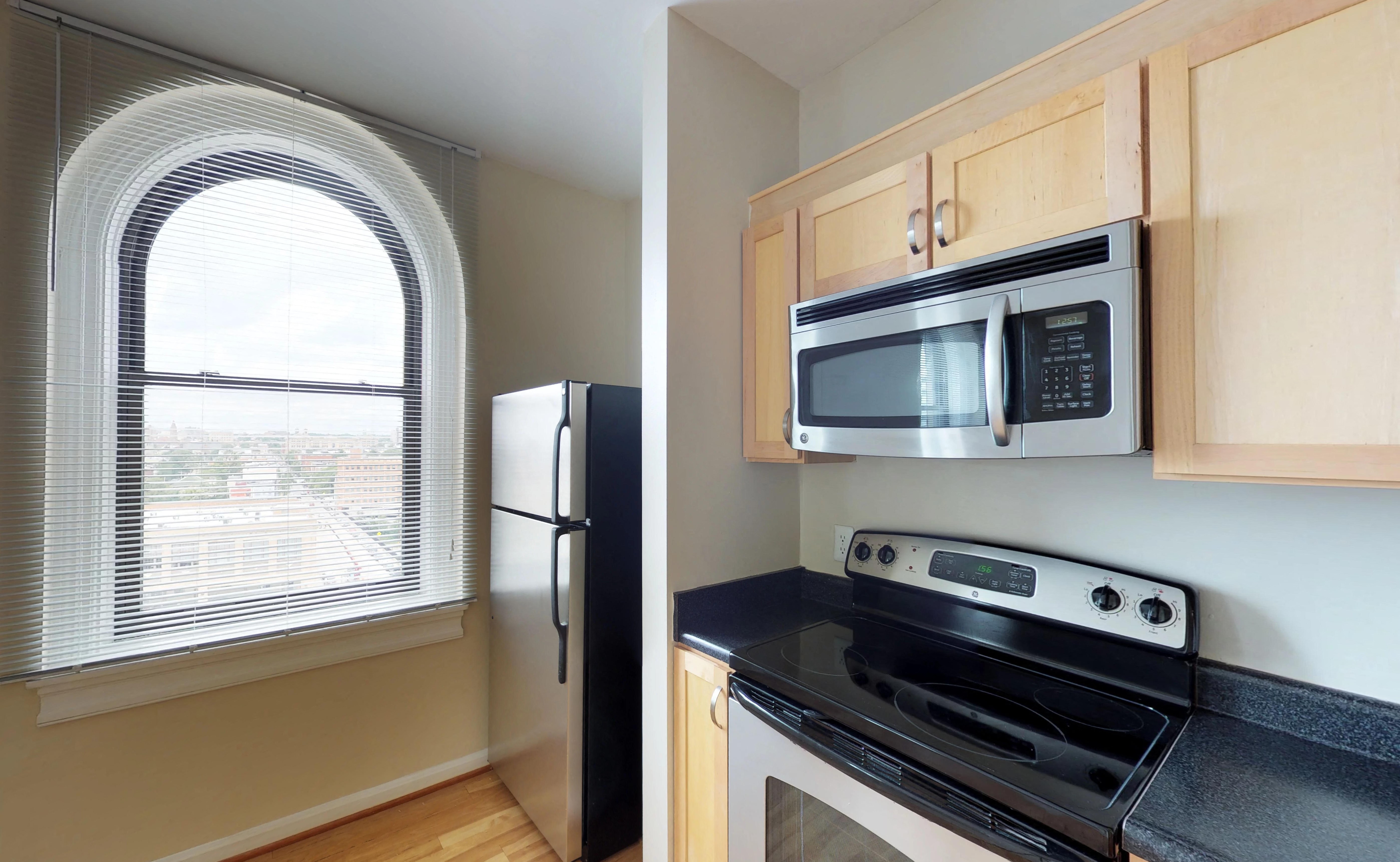 a kitchen with an arched window and a stove and refrigerator