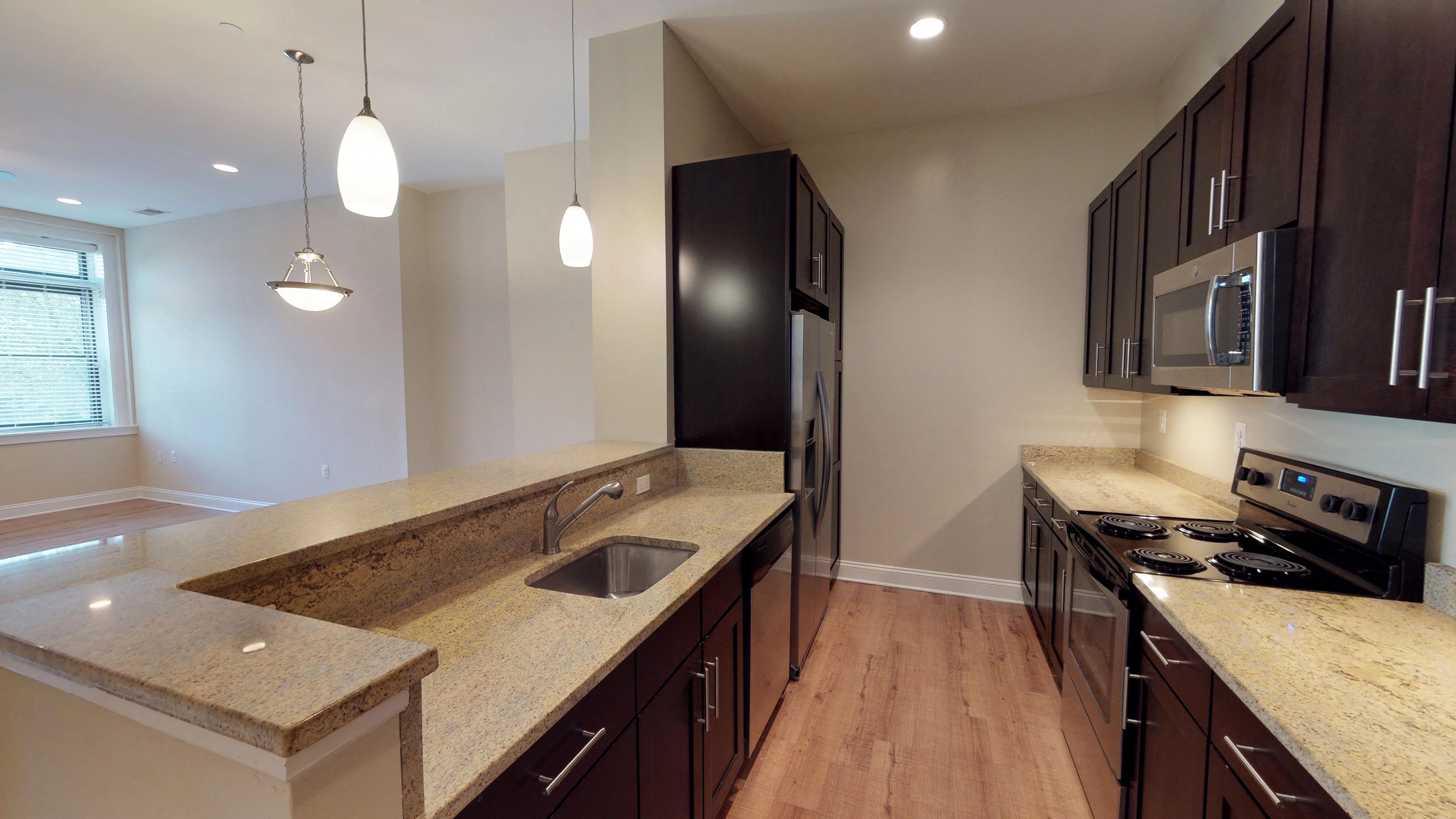 a large kitchen with granite counter tops and stainless steel appliances