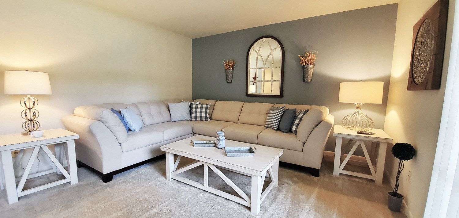 A living room with a white couch and a coffee table.