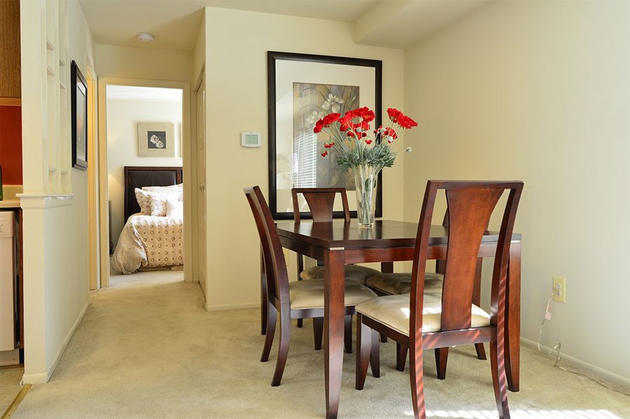 a dining room table with chairs and a vase of flowers