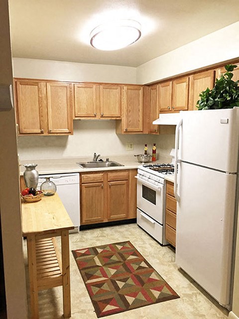 A kitchen with wooden cabinets and a white refrigerator.