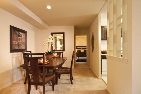 A dining room with a wooden table and chairs.