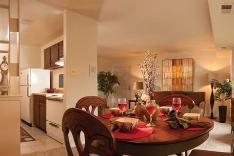 A dining room with a table set for a meal.
