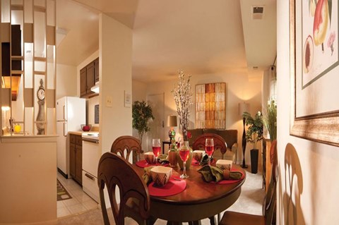 A dining room with a table set for a meal.