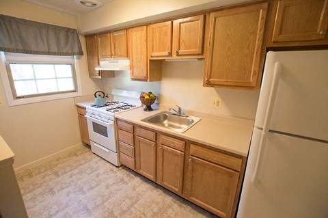 A kitchen with wooden cabinets and a white refrigerator.