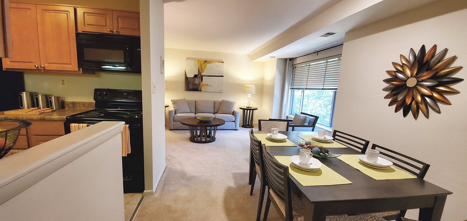 A modern kitchen with a dining table set for two.