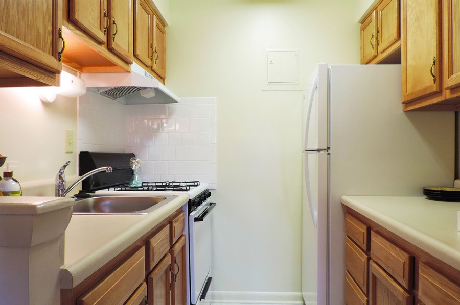 A kitchen with wooden cabinets and a white refrigerator.
