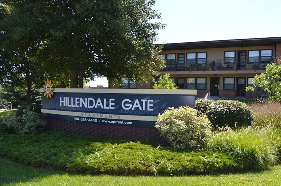 A sign for Hillendale Gate Apartments is displayed in front of a building.