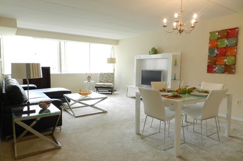 A living room with a dining table set up with chairs.