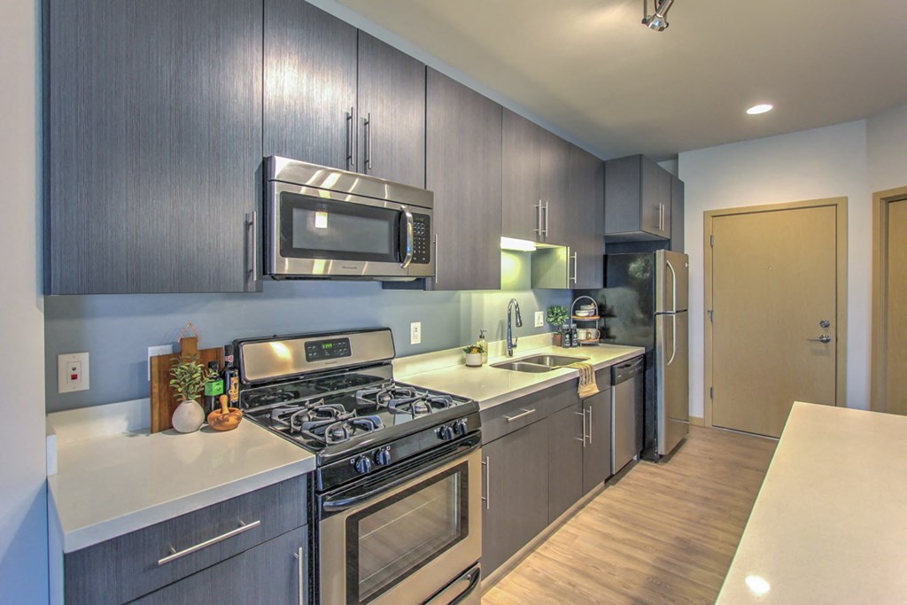 a kitchen with stainless steel appliances and white counter tops