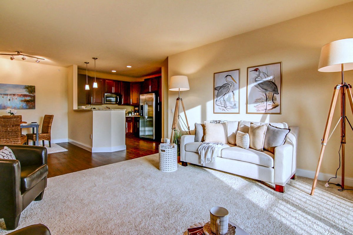 a living room with a couch and a kitchen in the background