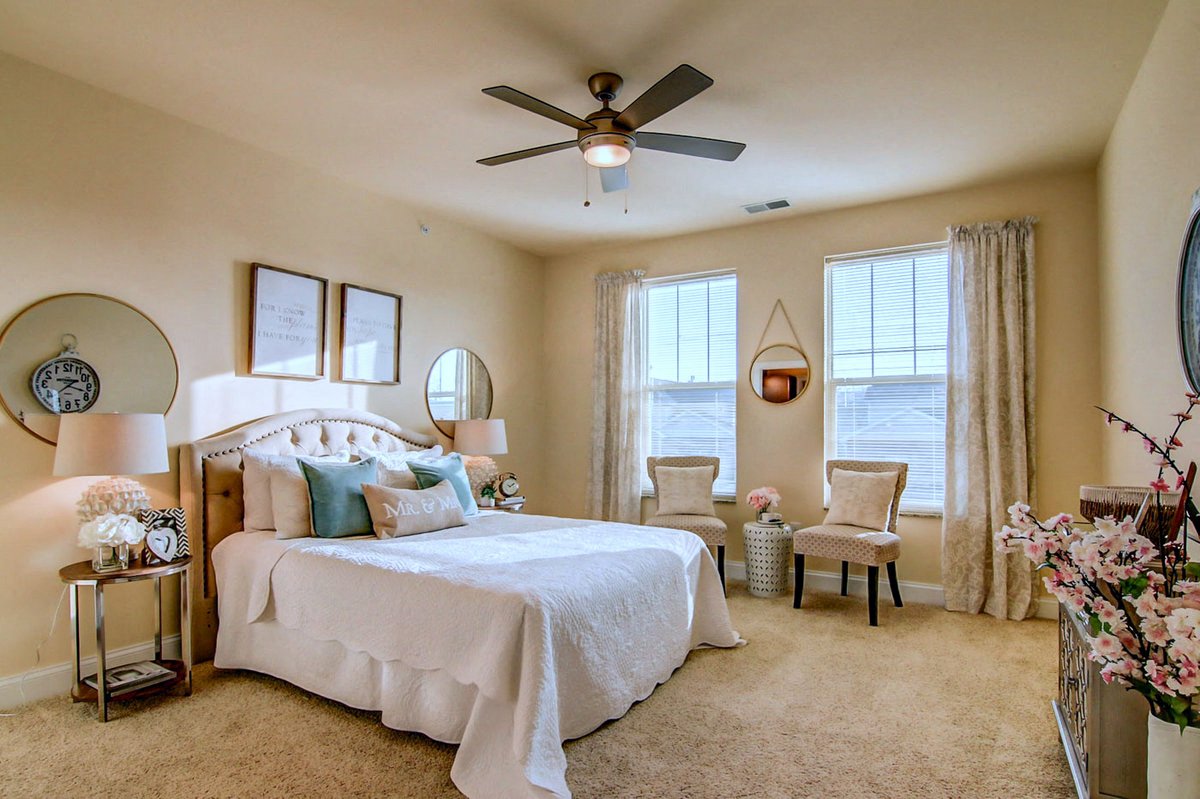 a bedroom with a large bed and a ceiling fan
