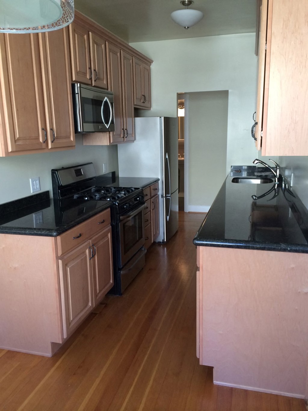 an empty kitchen with wooden floors and wooden cabinets
