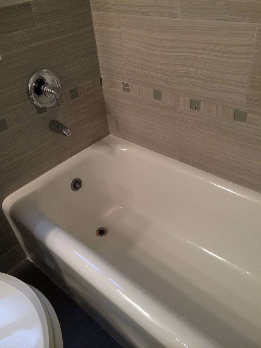 a white bath tub in a bathroom with a toilet