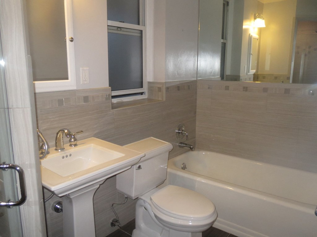 a bathroom with a sink toilet and a bath tub