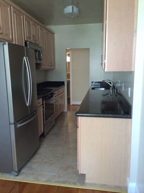 a kitchen with a stainless steel refrigerator and a sink