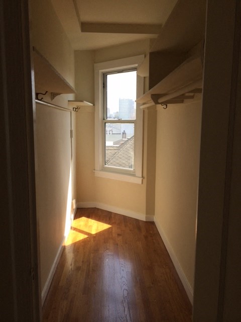 a small room with a window and wooden floors