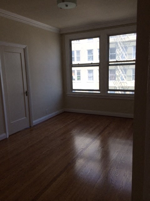 a living room with a wood floor and two windows
