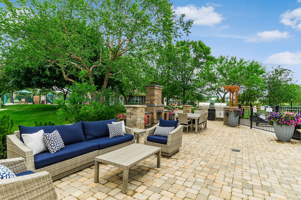 a patio with couches and tables on a brick patio