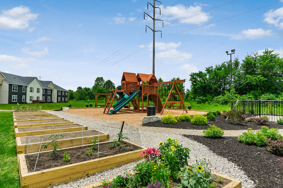 a playground with a swing set and other playground equipment in a garden