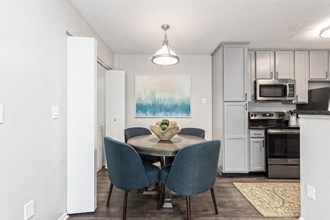 a dining room with a table and chairs and a kitchen