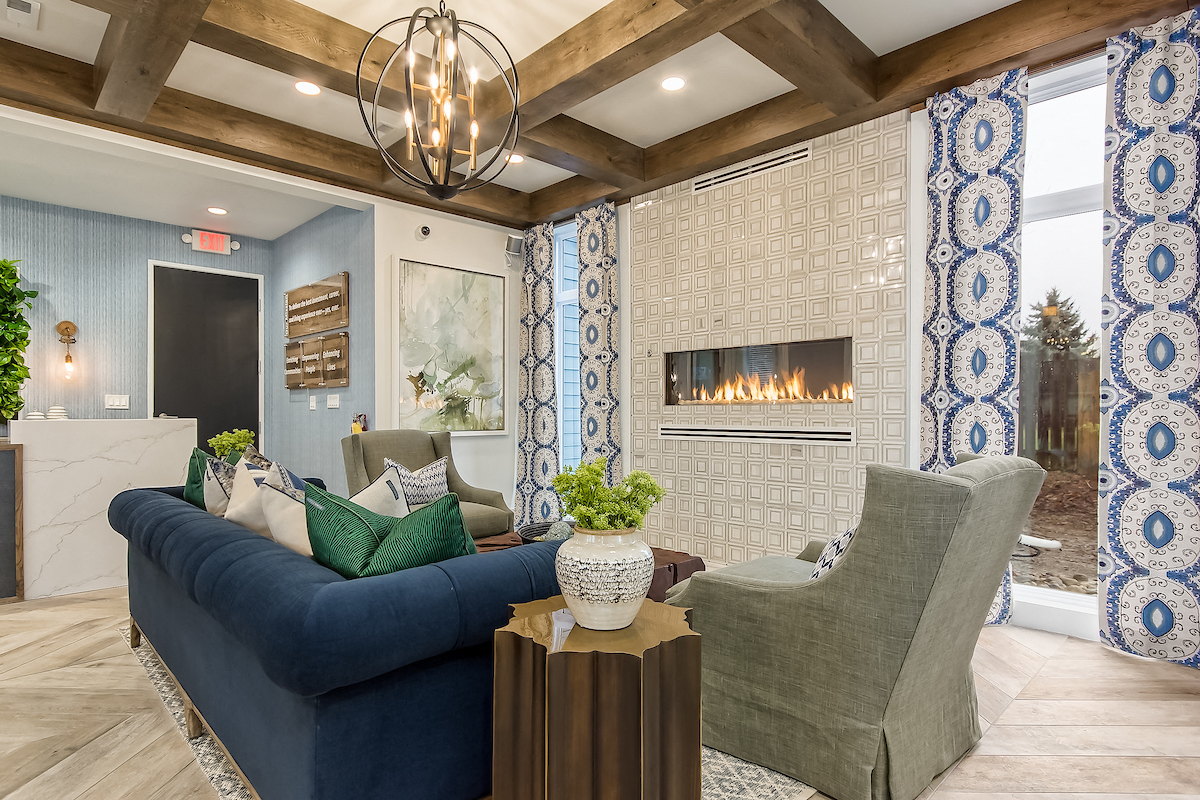 a living room with a blue couch and a fireplace