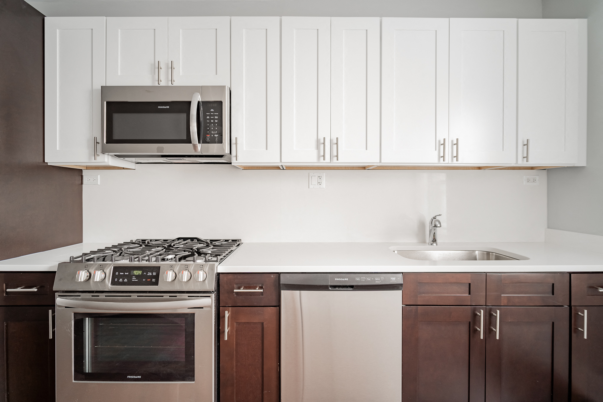 a kitchen with white cabinets and a stove and a microwave